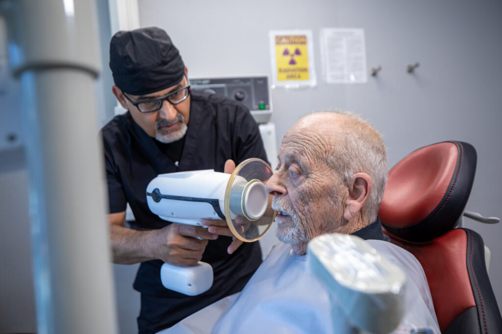 doctor using tech equipment to get a x-ray of patients teeth