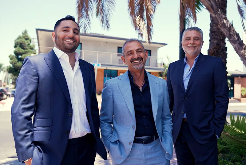 dentist standing outside in front of dental office smiling