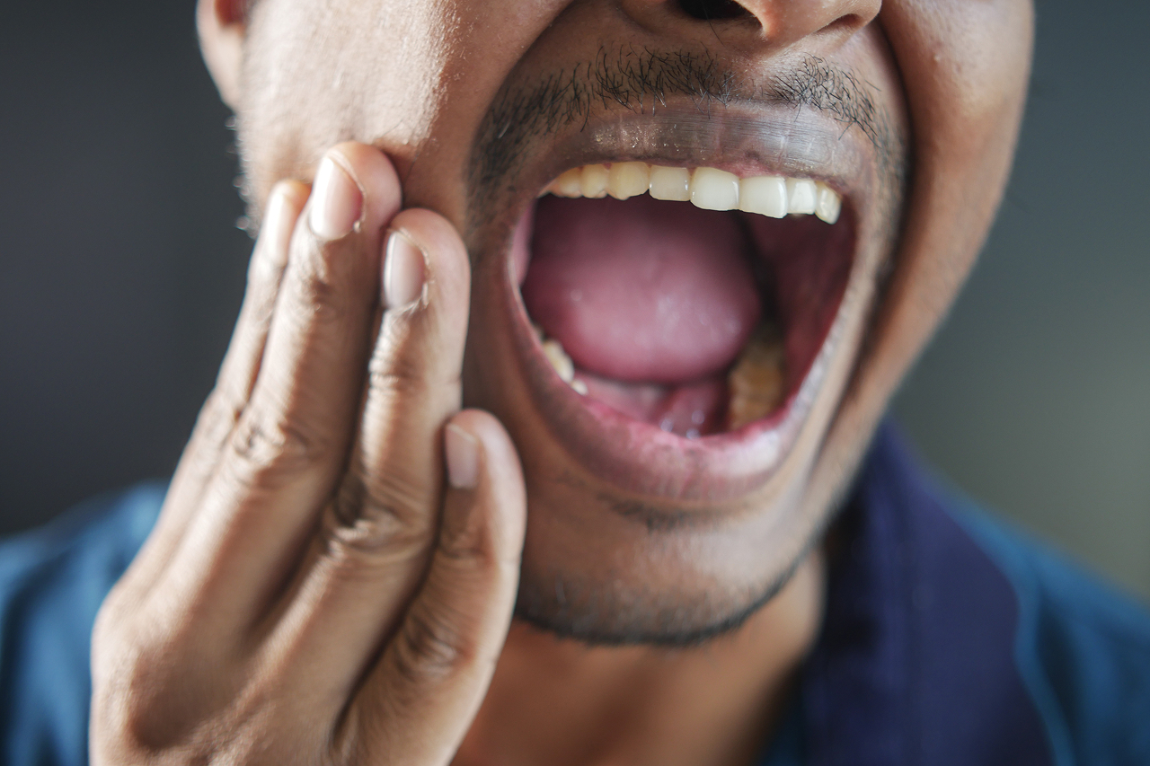 man-shows-toothache-pain-with-open-mouth